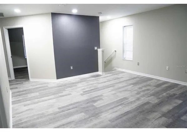 a view of empty room with wooden floor