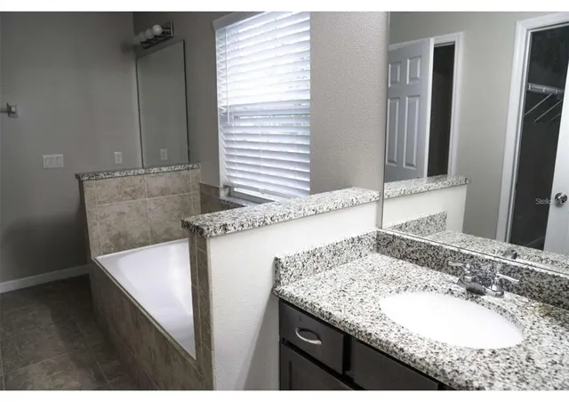 a bathroom with a granite countertop sink and a mirror