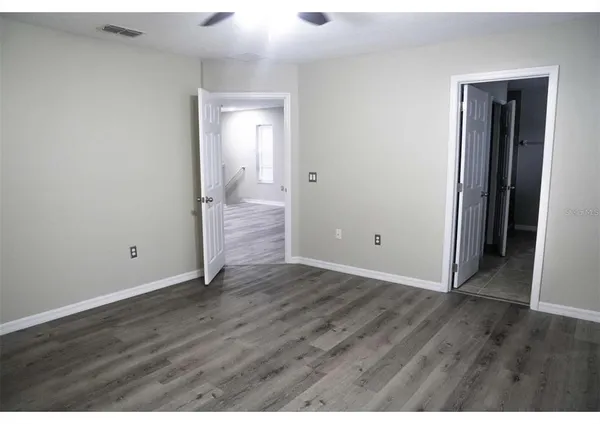 a view of an empty room with wooden floor