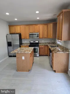 a kitchen with stainless steel appliances granite countertop a stove a sink dishwasher and a refrigerator