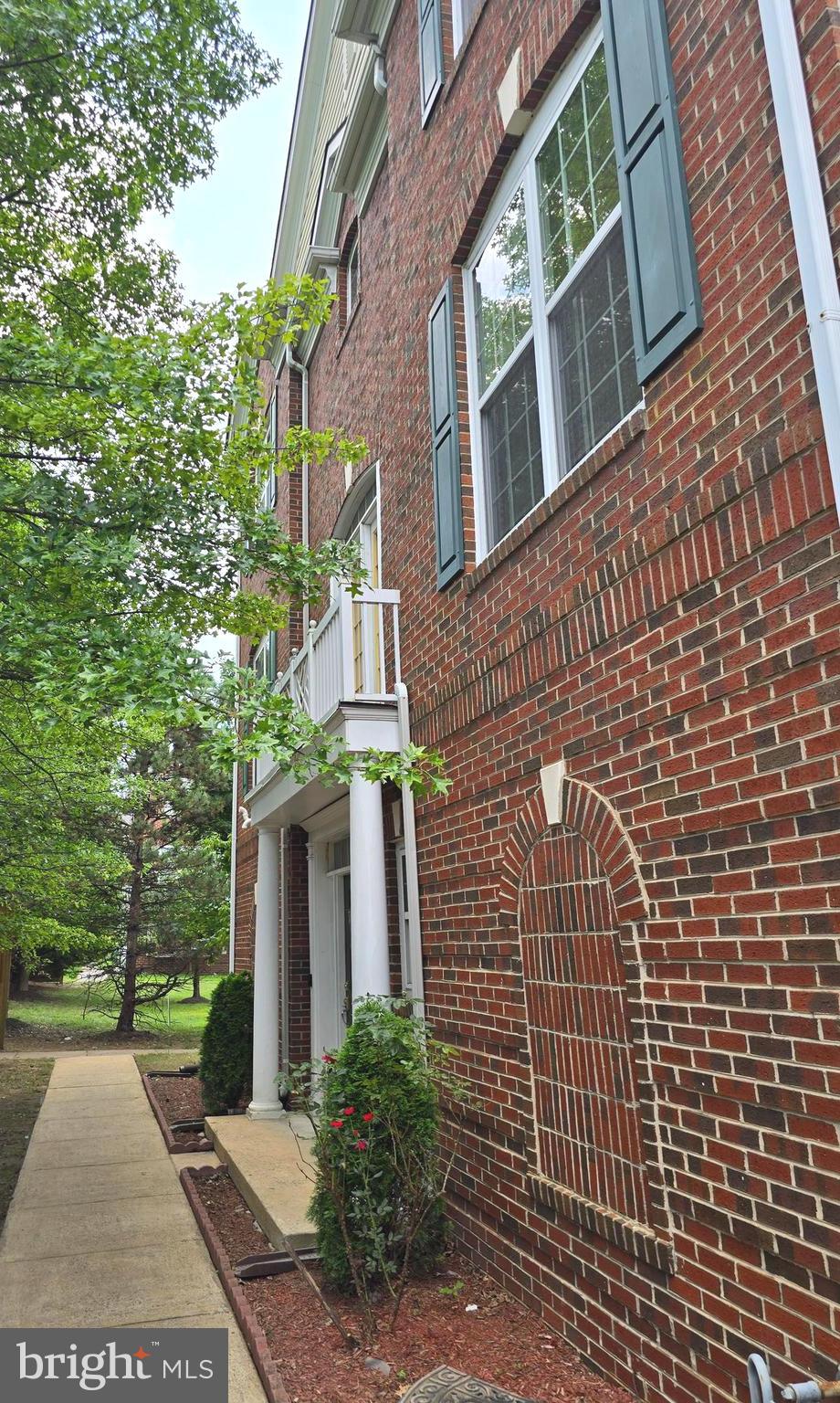 5019 Village Fountain Place Centreville, VA 20120 - Photo 2 of 17 a view of a brick building next to a yard