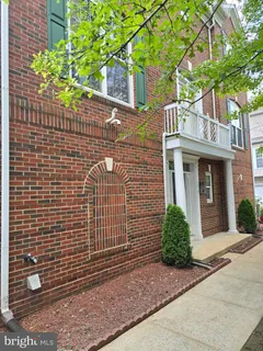 a view of a brick house with a flower garden