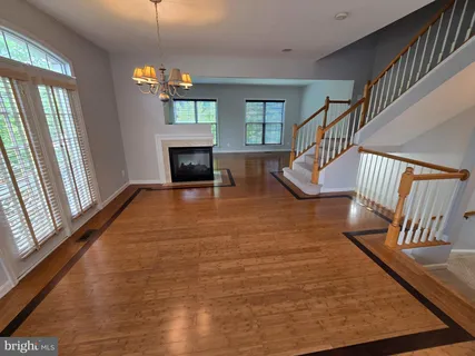 a view of an entryway with wooden floor fireplace and a window