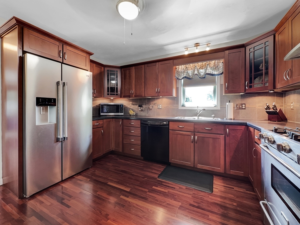 5 Wilson Street Wareham, MA 02571 - Photo 19 of 37 a kitchen with stainless steel appliances granite countertop a refrigerator a sink dishwasher a stove with wooden cabinets and floor