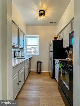 a kitchen with stainless steel appliances a refrigerator and a stove top oven