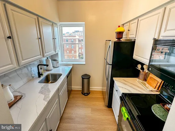 a kitchen with stainless steel appliances a stove a sink and a refrigerator