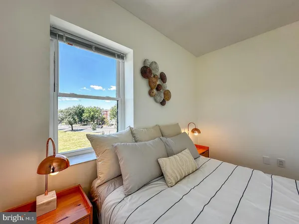 a bedroom with a bed and a painting on the wall