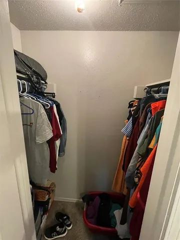 a view of walk in closet with clothes and shoes