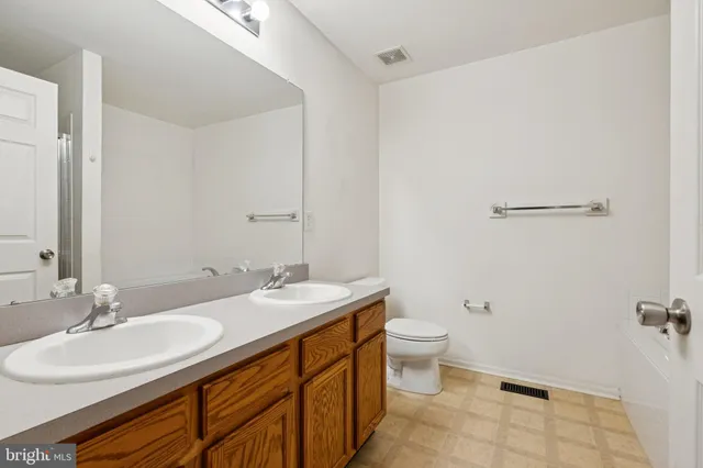 a bathroom with a granite countertop sink a toilet and a mirror