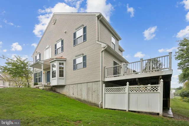 a view of an house with backyard and a tree