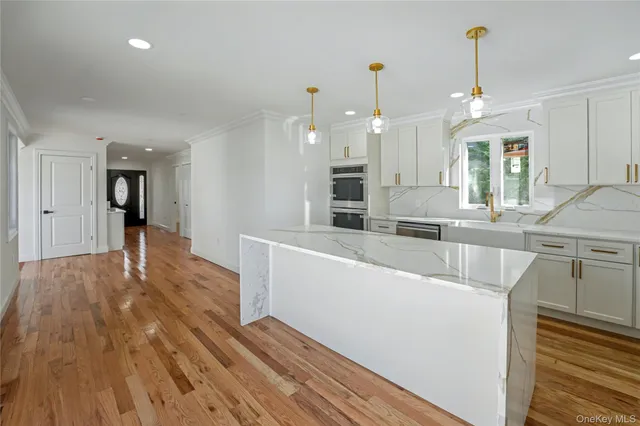 a large kitchen with kitchen island a stove a sink dishwasher and wooden floor