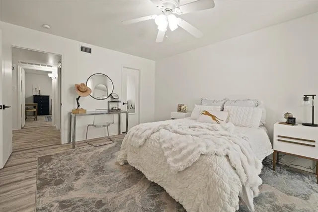 a bedroom with a bed a chandelier and a flat screen television