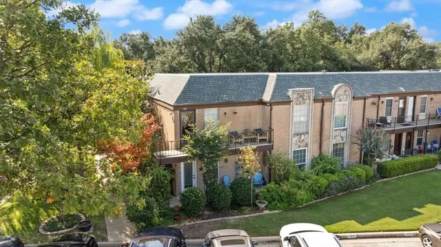 a view of a house with big yard and potted plants