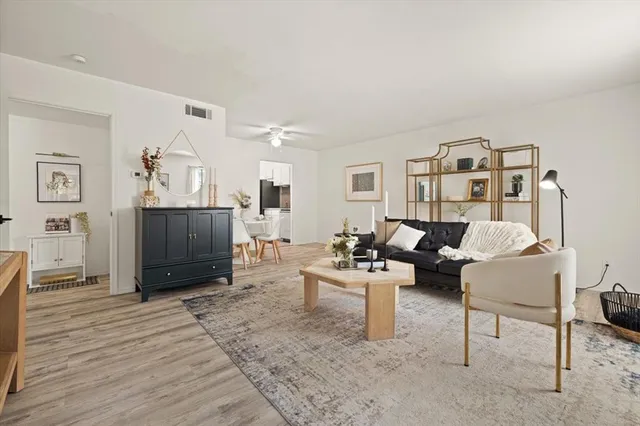 a living room with furniture a flat screen tv and a window