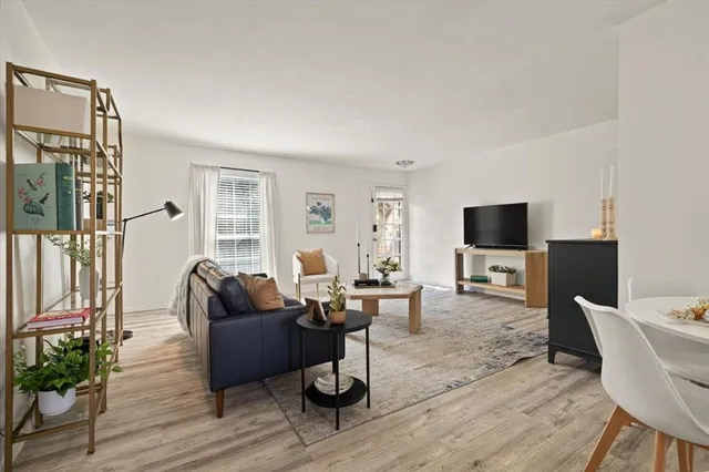 a work room with furniture a flat screen tv and a window