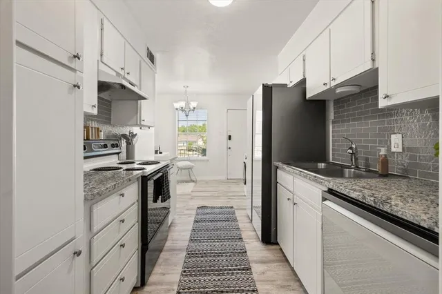 a kitchen with kitchen island granite countertop a stove and a refrigerator