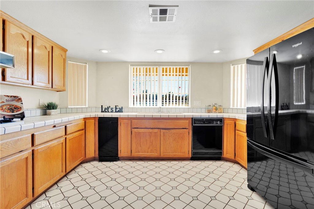 11062 Hollister Road Oak Hills, CA 92344 - Photo 16 of 69 a kitchen with stainless steel appliances granite countertop a sink and a refrigerator