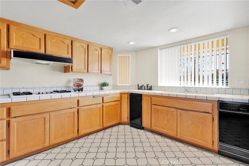 11062 Hollister Road Oak Hills, CA 92344 - Photo 17 of 69 a kitchen with stainless steel appliances granite countertop a sink and cabinets