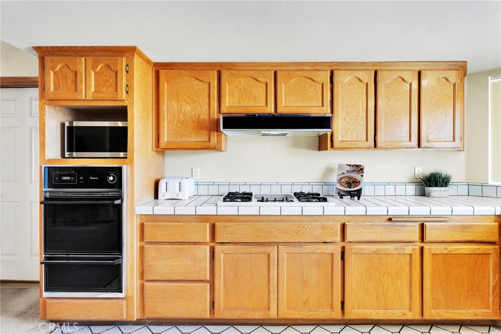 11062 Hollister Road Oak Hills, CA 92344 - Photo 18 of 69 a kitchen with stainless steel appliances granite countertop a stove and cabinets