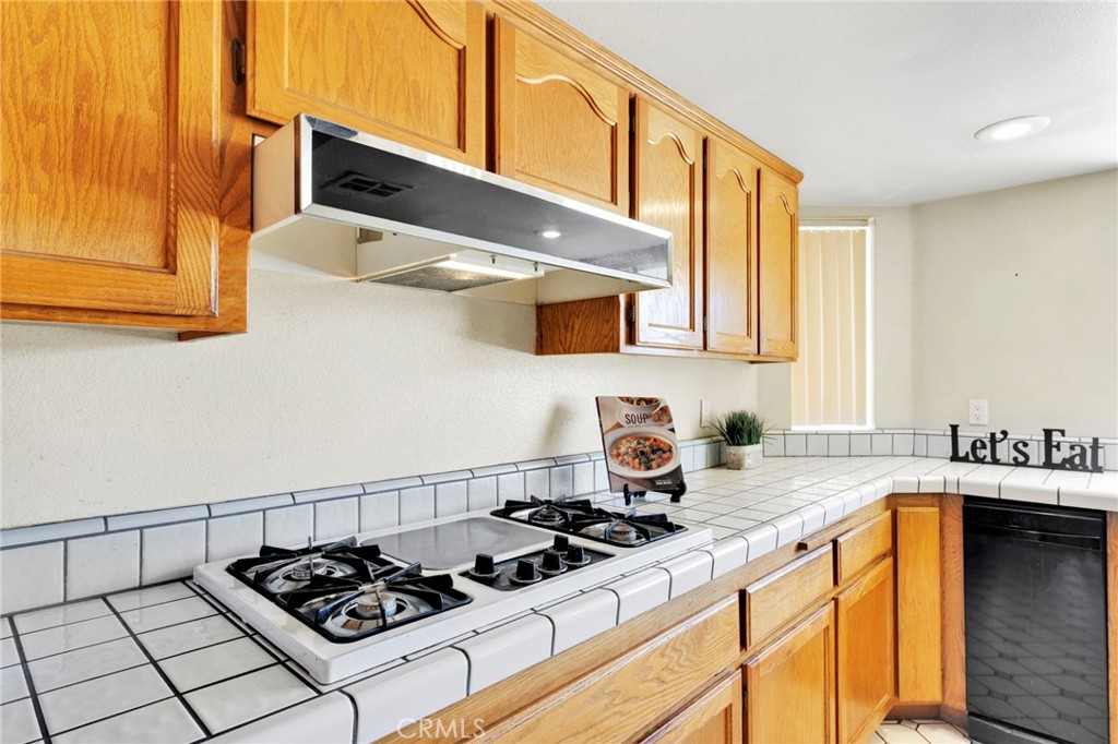 11062 Hollister Road Oak Hills, CA 92344 - Photo 19 of 69 a kitchen with stainless steel appliances a sink a stove and a microwave