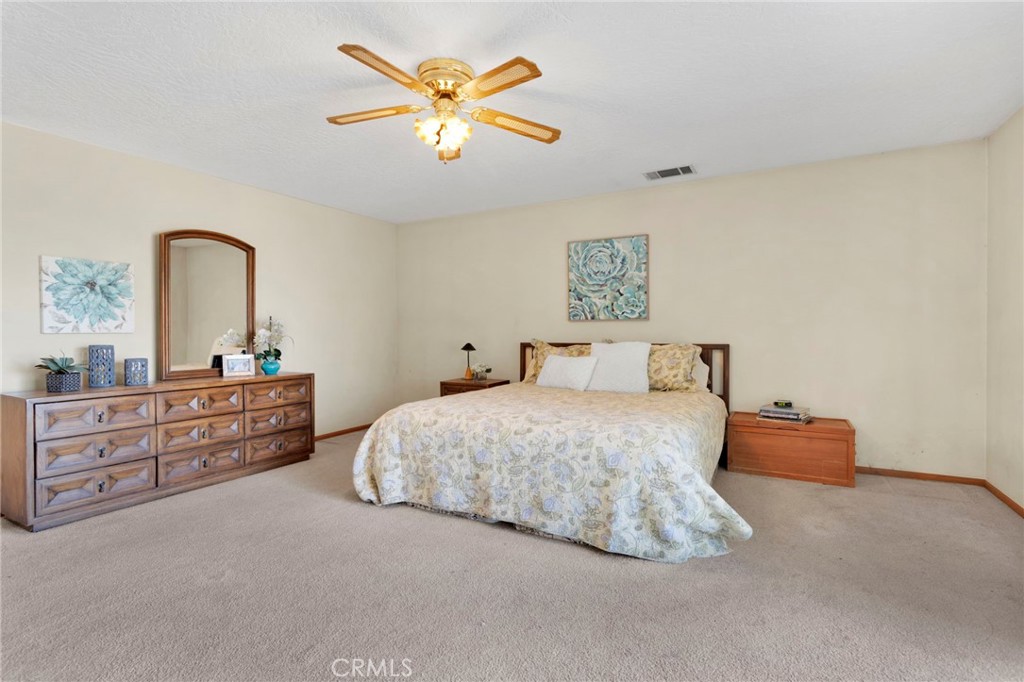 11062 Hollister Road Oak Hills, CA 92344 - Photo 28 of 69 a bed room with a bed and a chandelier