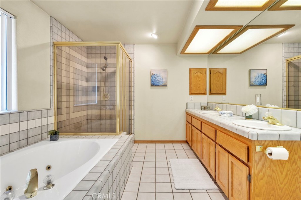 11062 Hollister Road Oak Hills, CA 92344 - Photo 32 of 69 a bathroom with a tub sink and mirror