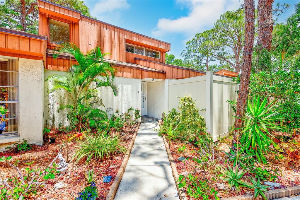 2064 Sunset Point Road, Unit 73 Clearwater, FL 33765 - Photo 43 of 58 a front view of a house with a yard and potted plants