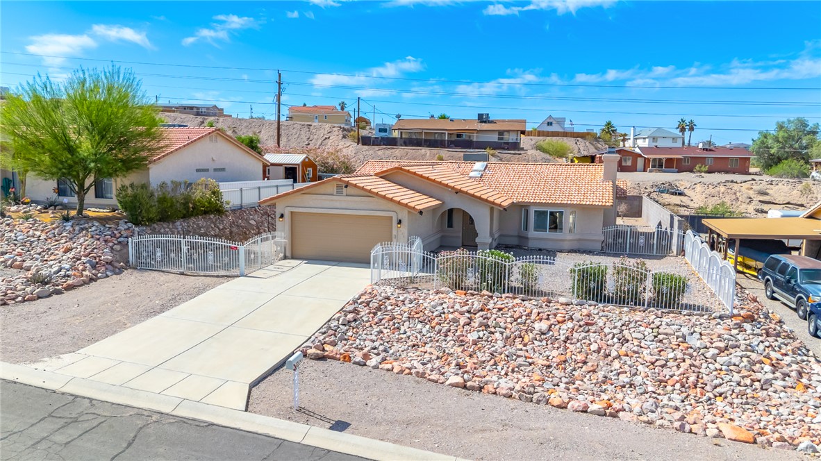 2524 South Ridge Avenue Bullhead City, AZ 86429 - Photo 63 of 64 Ranch-style home featuring a fenced front yard, a garage, a tile roof, and stucco siding