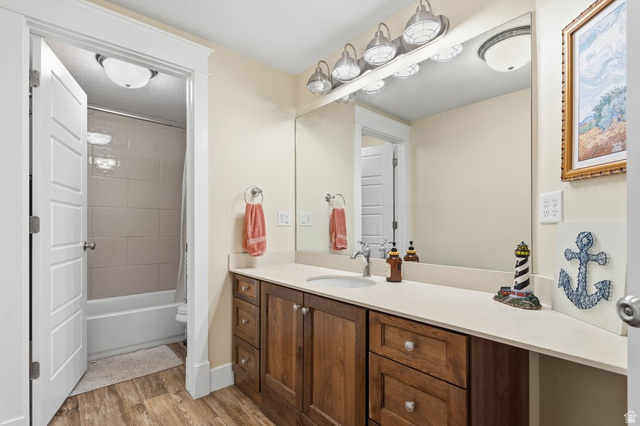 672 Perry Hollow Drive Mapleton, UT 84664 - Photo 67 of 106 Bathroom featuring a wood-finish vanity with a light-toned countertop, an integrated sink, and a large mirror