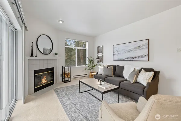a living room with furniture a fireplace and a large window