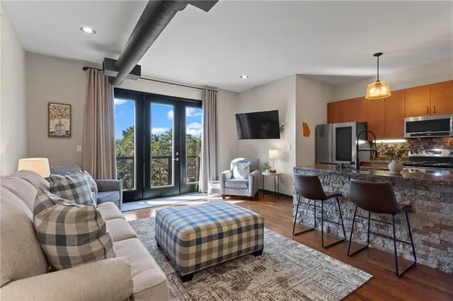 a living room with furniture a ceiling fan and a flat screen tv