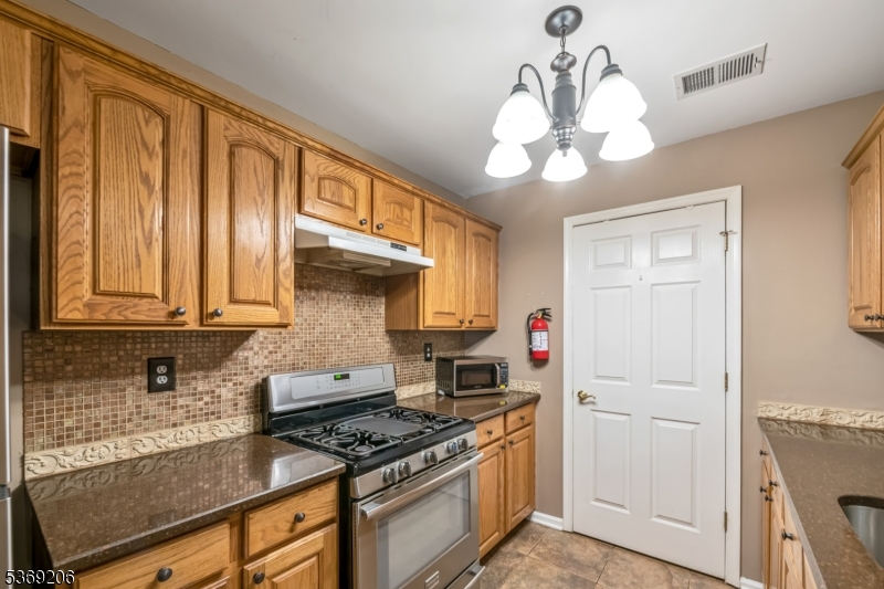1096 Coventry Way Mahwah, NJ 07430 - Photo 8 of 28 a kitchen with stainless steel appliances granite countertop a stove and a white cabinets