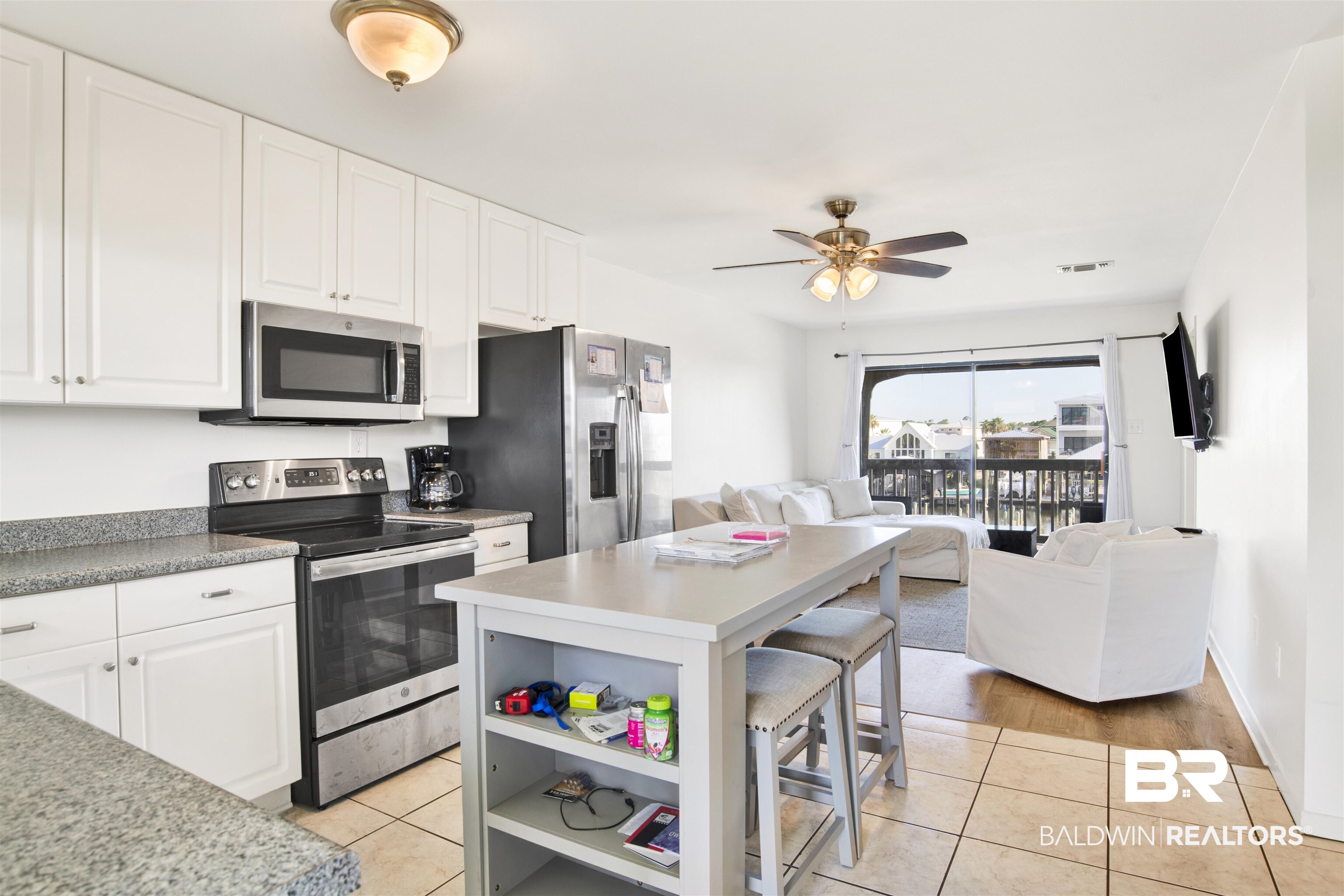 26913 Marina Road, Unit 213 Orange Beach, AL 36561 - Photo 15 of 30 Kitchen with ceiling fan, a kitchen island, stainless steel appliances, and light tile patterned flooring
