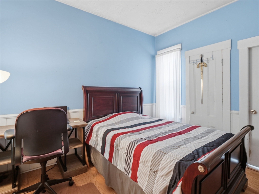 223 Stackpole Street Lowell, MA 01852 - Photo 9 of 42 a bedroom with a bed chair and a window