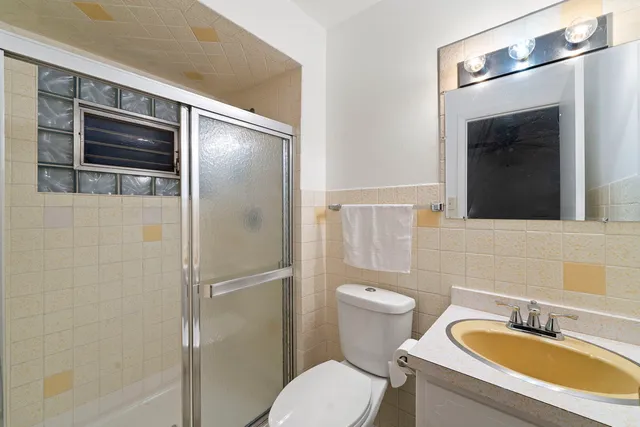 a bathroom with a granite countertop toilet sink and shower