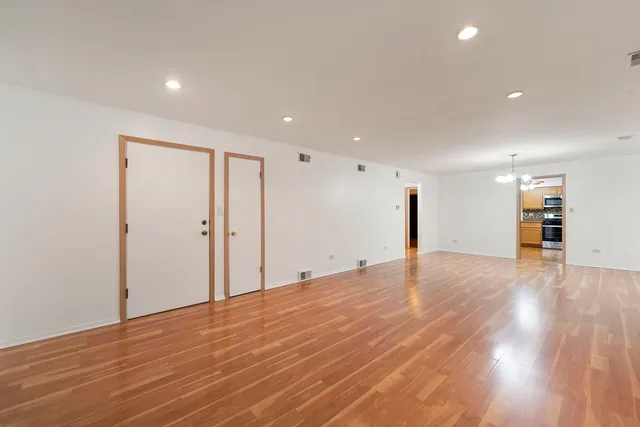 a view of empty room with wooden floor