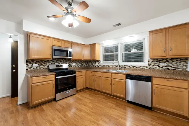 a kitchen with granite countertop appliances cabinets and a sink