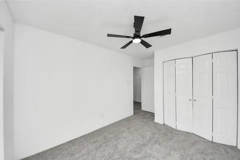 a view of a hallway with a ceiling fan
