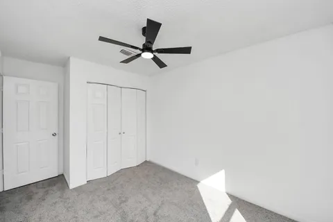 a view of a livingroom with a ceiling fan and entryway