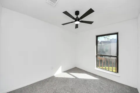a view of a big room with wooden floor and windows