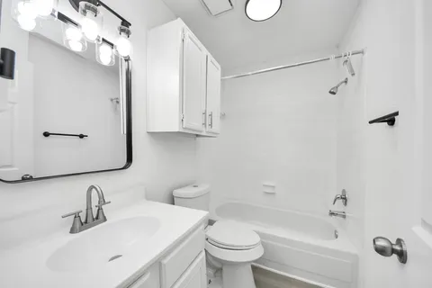 a bathroom with a sink toilet vanity and shower