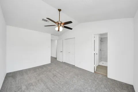 an empty room with a ceiling fan and a fan