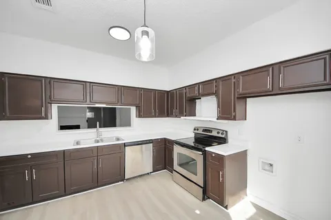 a kitchen with a sink cabinets and stainless steel appliances