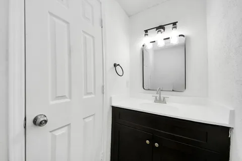 a bathroom with a sink vanity and mirror