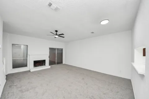 an empty room with fireplace and fan