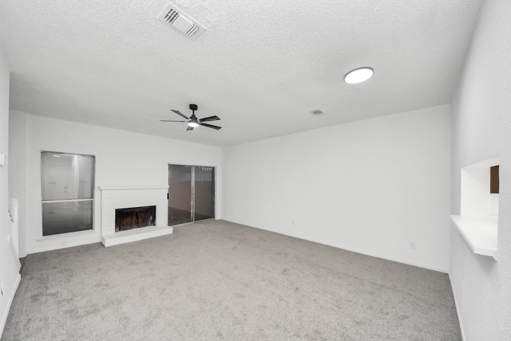 12500 Brookglade Circle, Unit 176 Houston, TX 77099 - Photo 9 of 25 an empty room with fireplace and fan