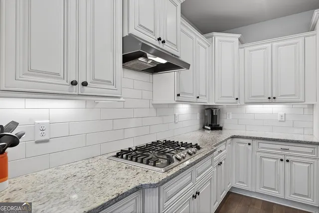 a kitchen with white cabinets and appliances