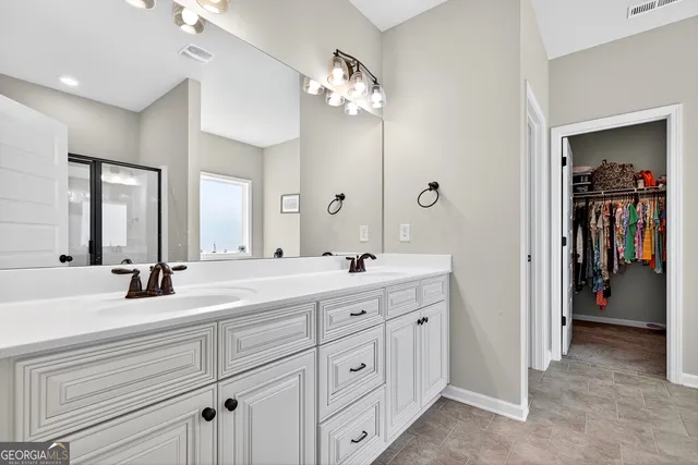 a spacious en suite bathroom with double sink and a large mirror
