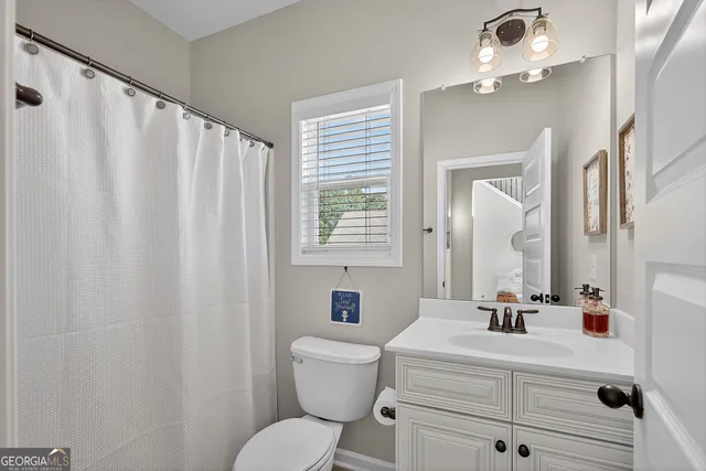 a bathroom with a toilet a sink and a mirror