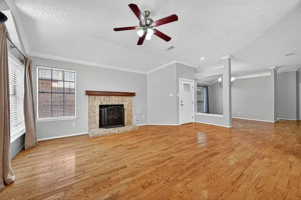 a view of an empty room with a fireplace and a window